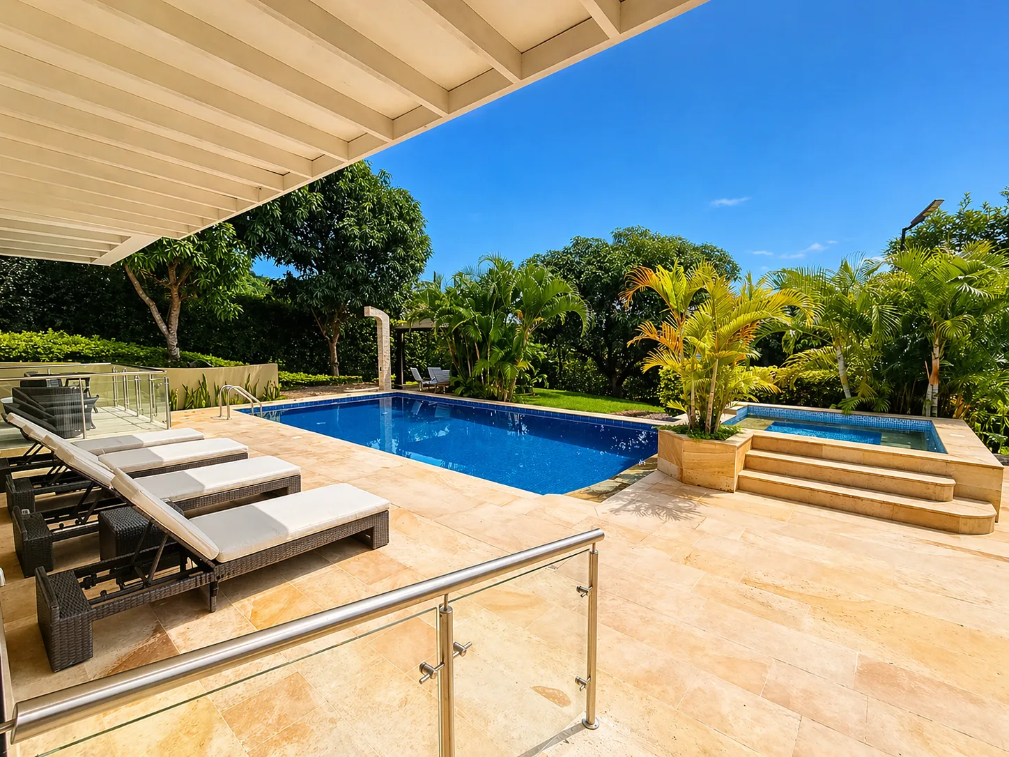 Piscina con sillas lounge desde terraza cubierta